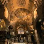 Ornate cathedral interior with detailed ceiling frescoes.