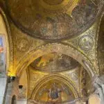 Ornate golden mosaic ceiling in ancient cathedral.
