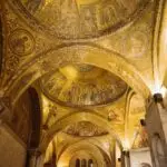 Golden Byzantine church ceiling with religious mosaics.