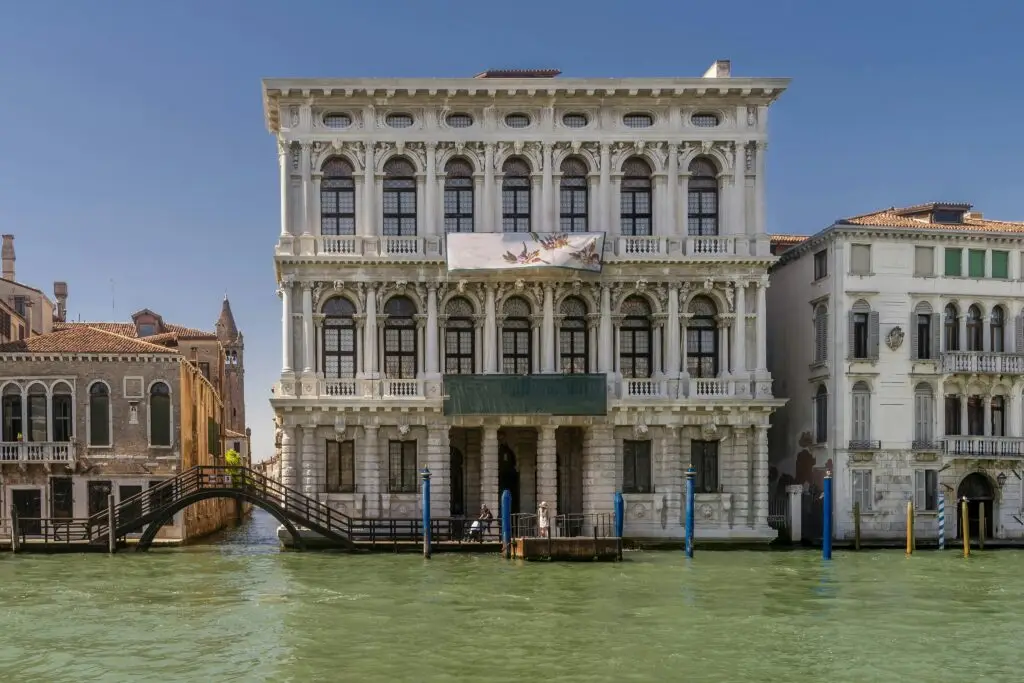 Historic Venetian building with canal view, sunny day.